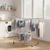 Foldable 2-tier clothes drying rack in a laundry room, featuring a sturdy aluminum and stainless steel design for.