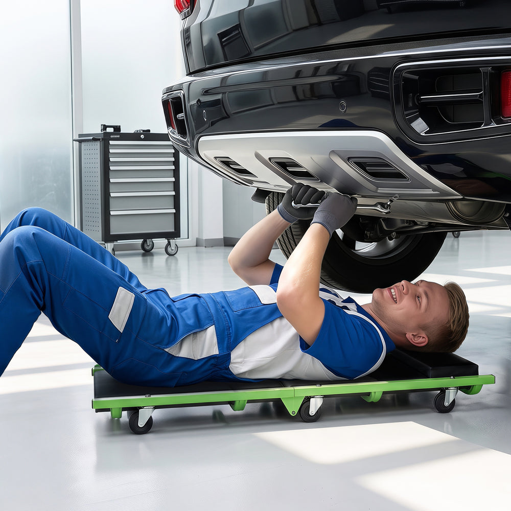 Foldable automotive creeper with thick padded cushion and 360° swivel wheels for easy under-car access and comfort.