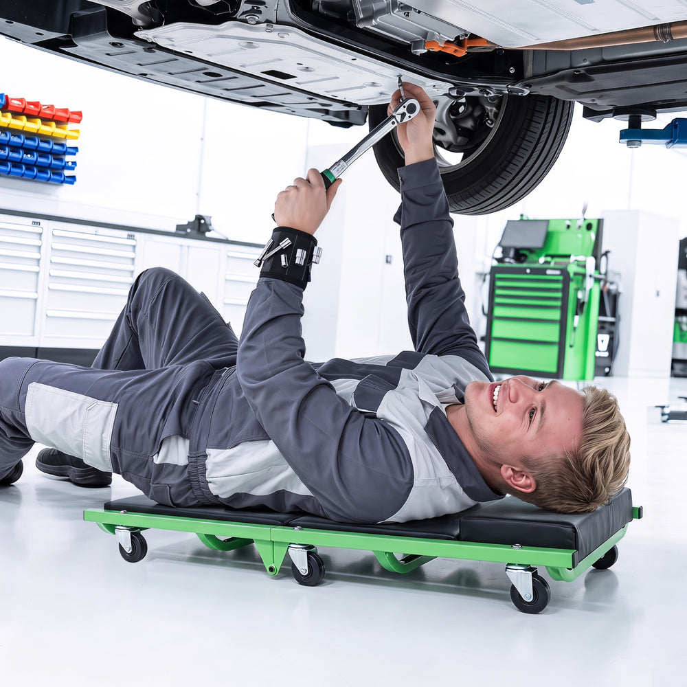 Foldable automotive creeper with thick padded cushion and 360° swivel wheels for comfortable under-car access.