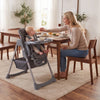 Foldable high chair for babies and toddlers in gray, featuring adjustable height, removable tray, and padded seat for easy cleanup.