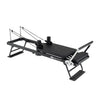 Foldable Pilates reformer machine in black for home gym, featuring adjustable resistance and compact design.