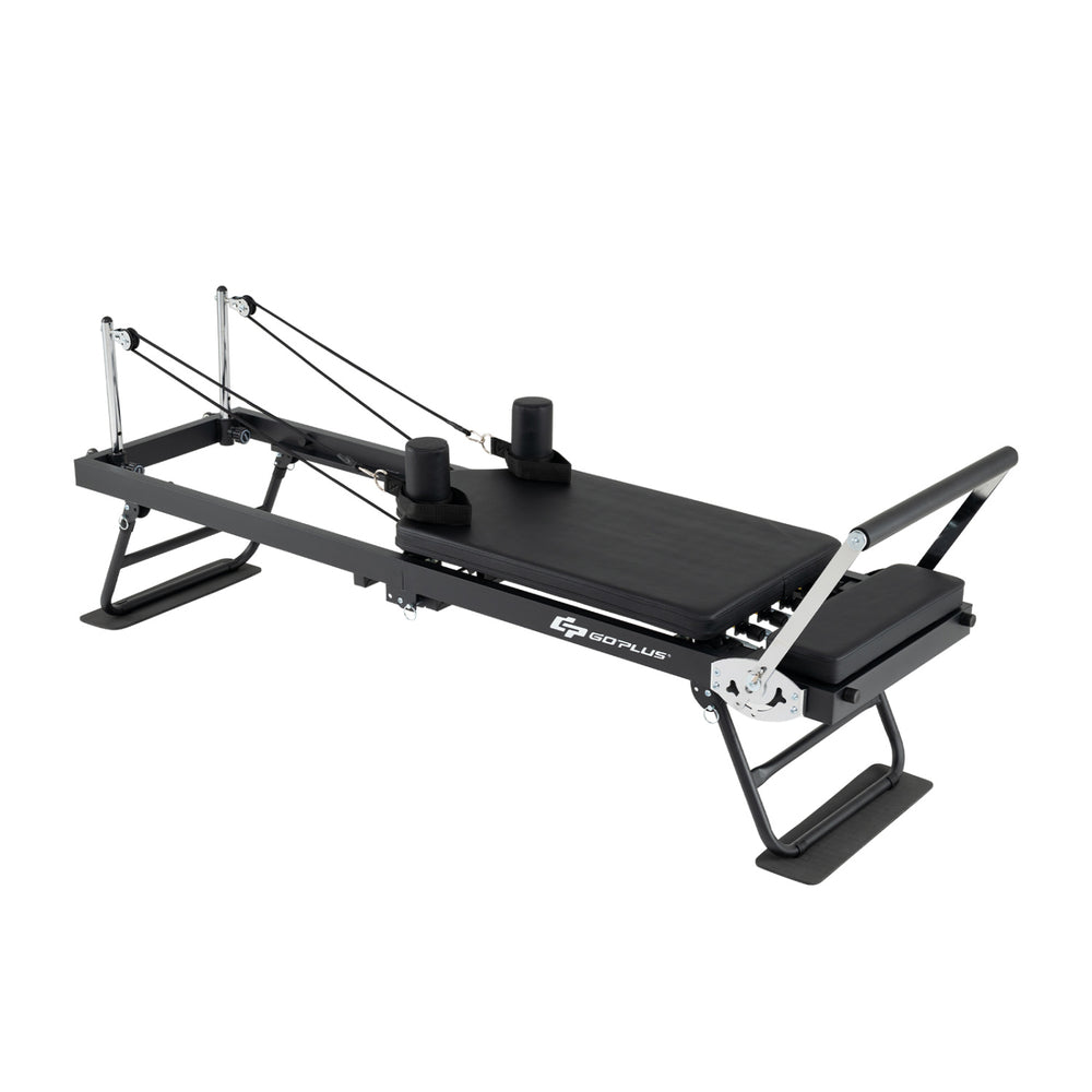Foldable Pilates reformer machine in black for home gym, featuring adjustable resistance and compact design.