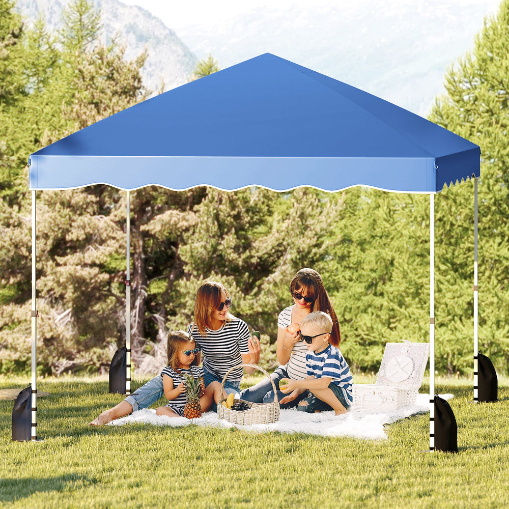 Foldable 10x10 feet blue pop-up canopy tent providing shade for family picnics and outdoor events in a grassy area.