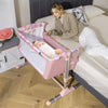Folding baby bassinet bedside sleeper in pink with adjustable height, detachable side rail, and soft mattress for easy.