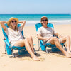 Two blue folding beach chairs with padded armrests, perfect for outdoor relaxation at the beach or camping.
