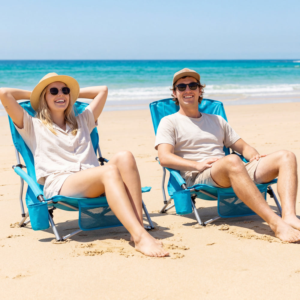 Two blue folding beach chairs with padded armrests, perfect for outdoor relaxation at the beach or camping.