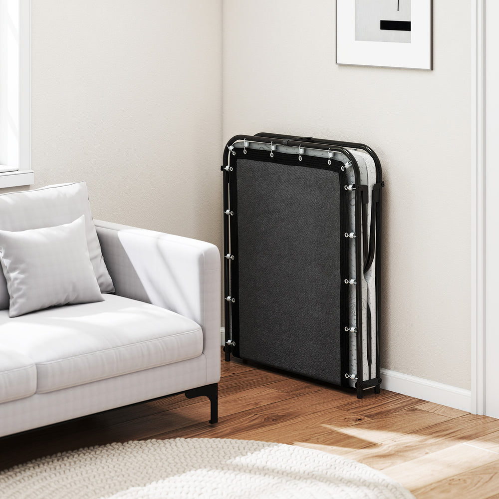 Folding bed with mattress in corner, featuring gel memory foam and a sturdy metal frame for versatile use.