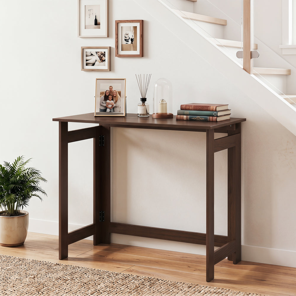 Brown folding console table with foldable legs, featuring a spacious tabletop and sturdy construction for entryways or.