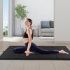 Black 4-panel folding exercise mat with carrying handles, ideal for stretching and gymnastics in a modern living space.
