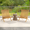 Two folding teak wood outdoor lounge chairs with slatted seats and backrests, perfect for patio relaxation.