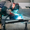 Folding welding table with adjustable height and tiltable tabletop, designed for efficient welding and tool.