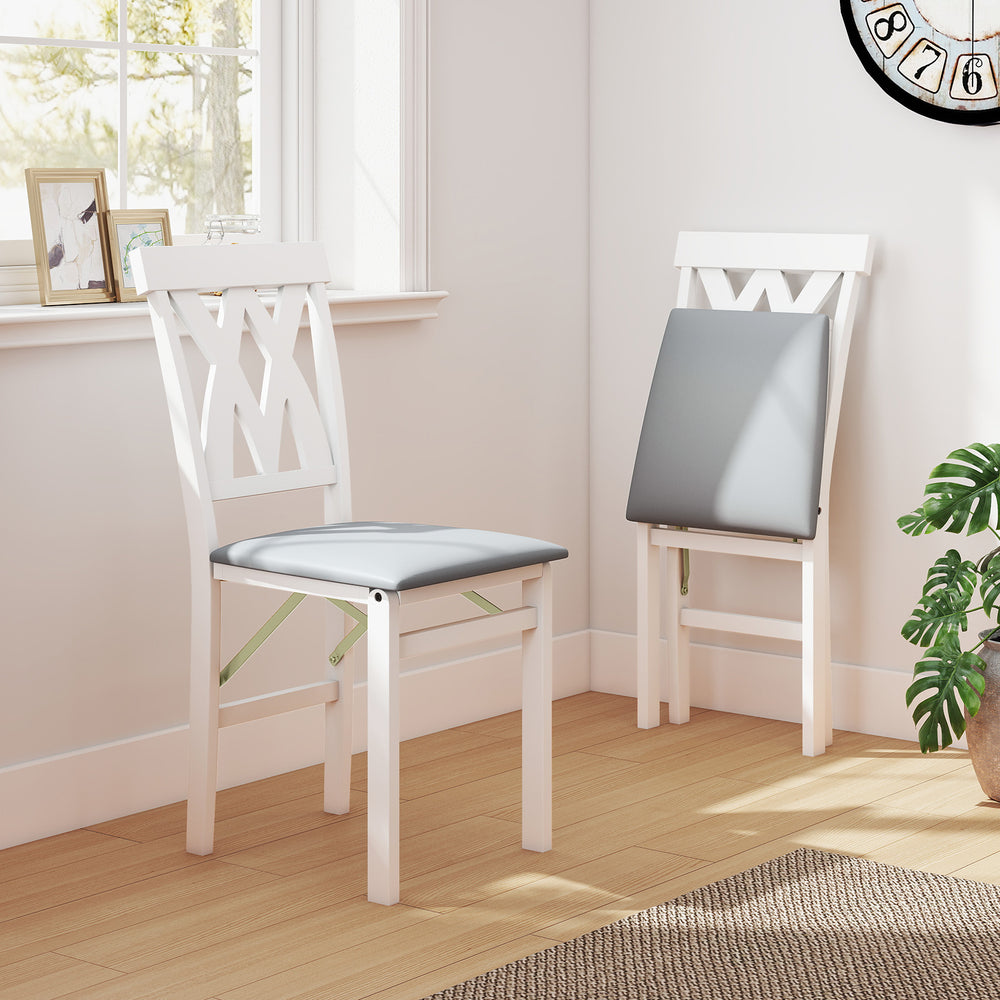 White folding wooden dining chairs with grey faux leather upholstery, ideal for small spaces and comfortable seating.