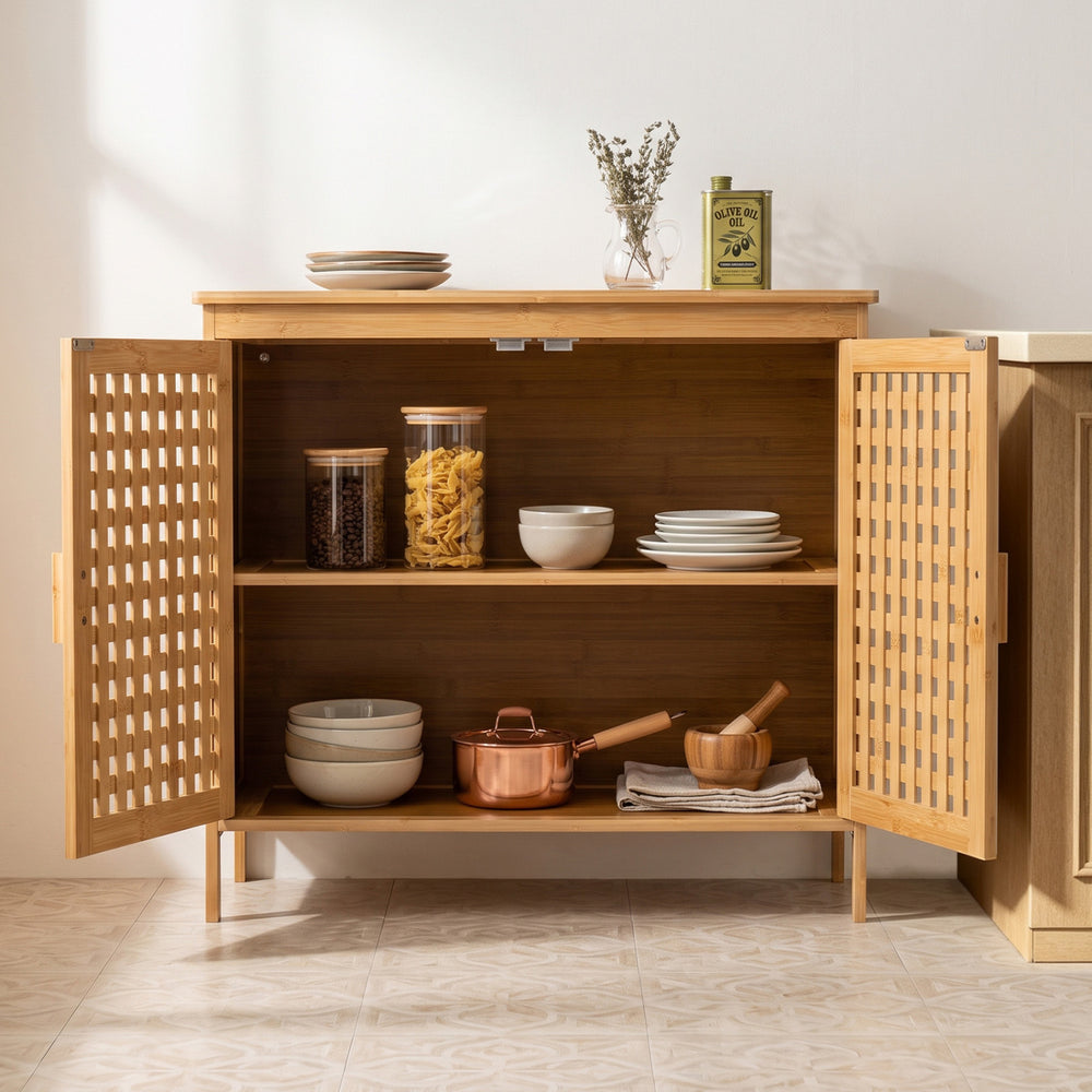 Bamboo bathroom storage cabinet with two doors, featuring ventilated hollowed-out doors and sturdy elevated legs for durability.
