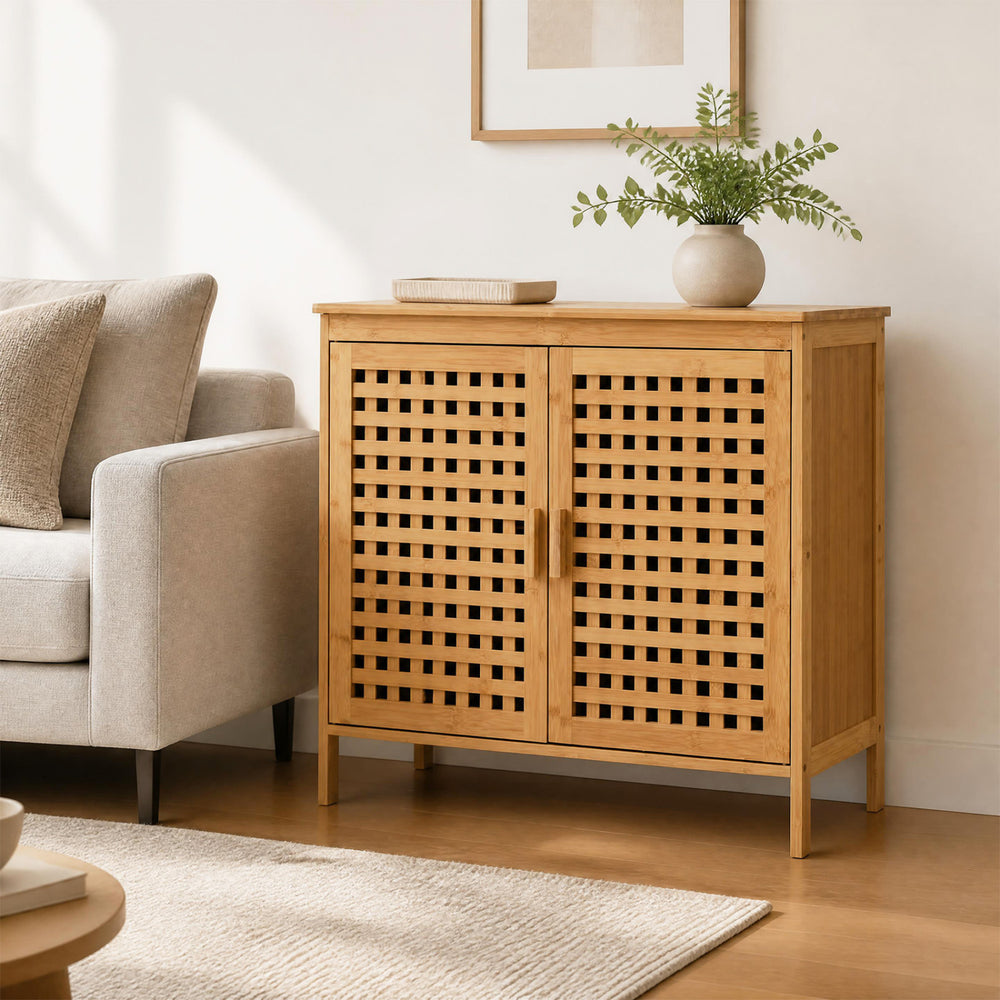 Bamboo bathroom storage cabinet with 2 doors, featuring hollowed-out doors and elevated legs for stylish organization.