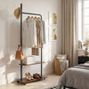 Freestanding clothing rack in rustic brown with wheels, featuring hanging rod and storage shelves for bedroom.