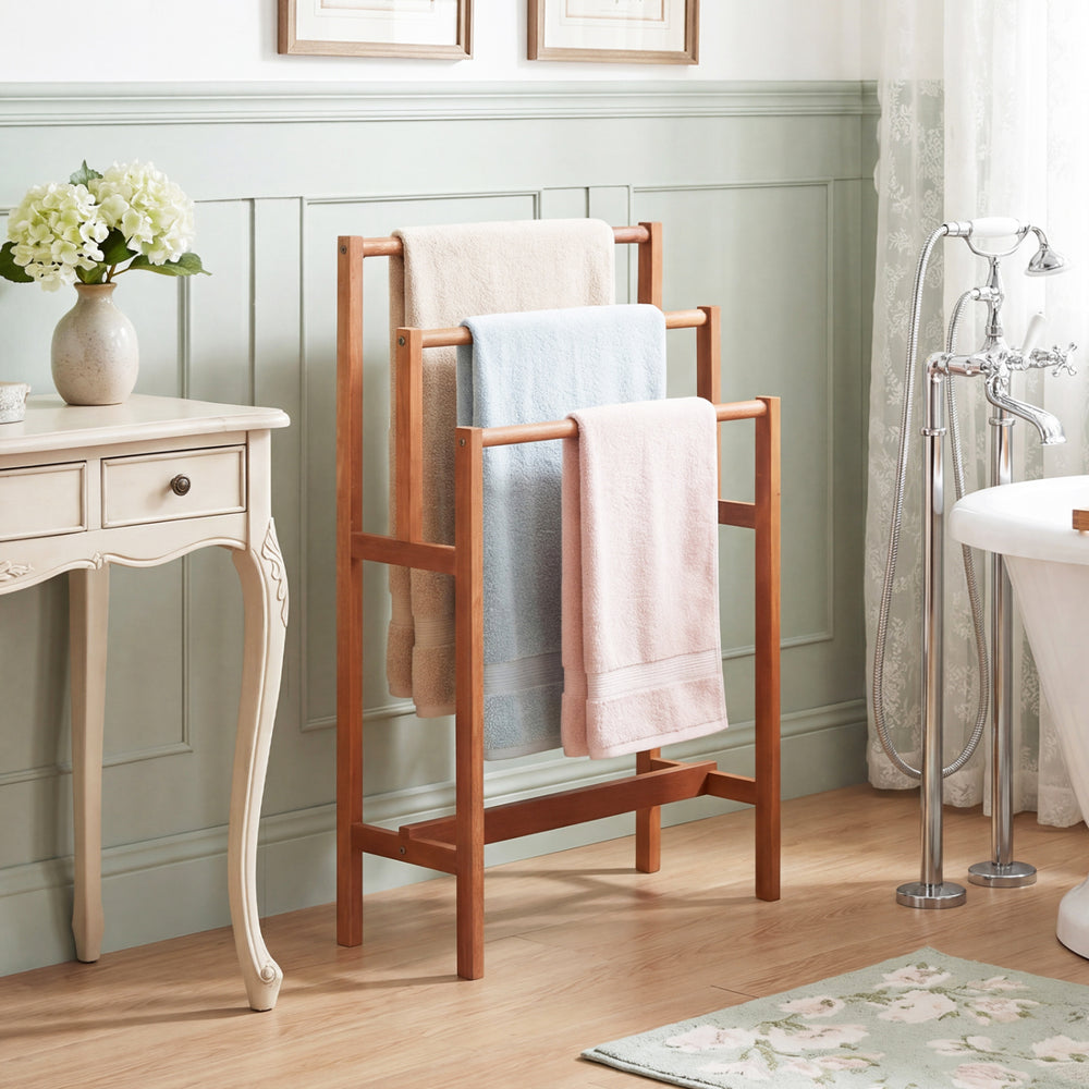 Freestanding solid wood towel rack with teak oil finish, featuring three tiers for organized bathroom storage.