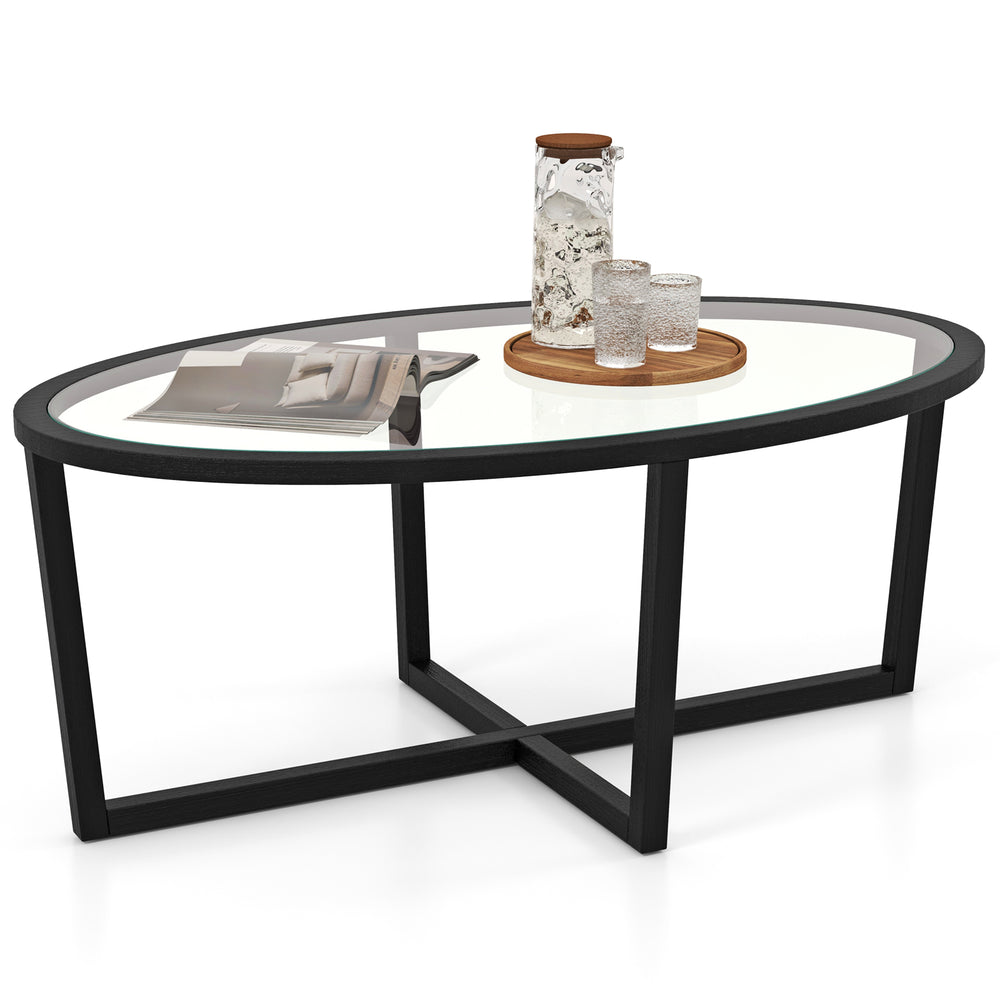 Oval glass coffee table with black cross base and acacia wood legs, perfect for living room decor and stability.
