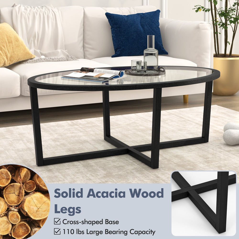 Oval glass coffee table with solid acacia wood legs and cross base, designed for stability and easy cleaning in living.