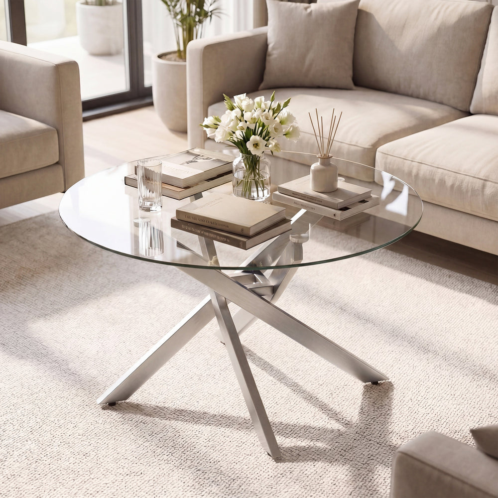 Round coffee table with a clear tempered glass top, featuring a stylish silver frame, perfect for enhancing modern.