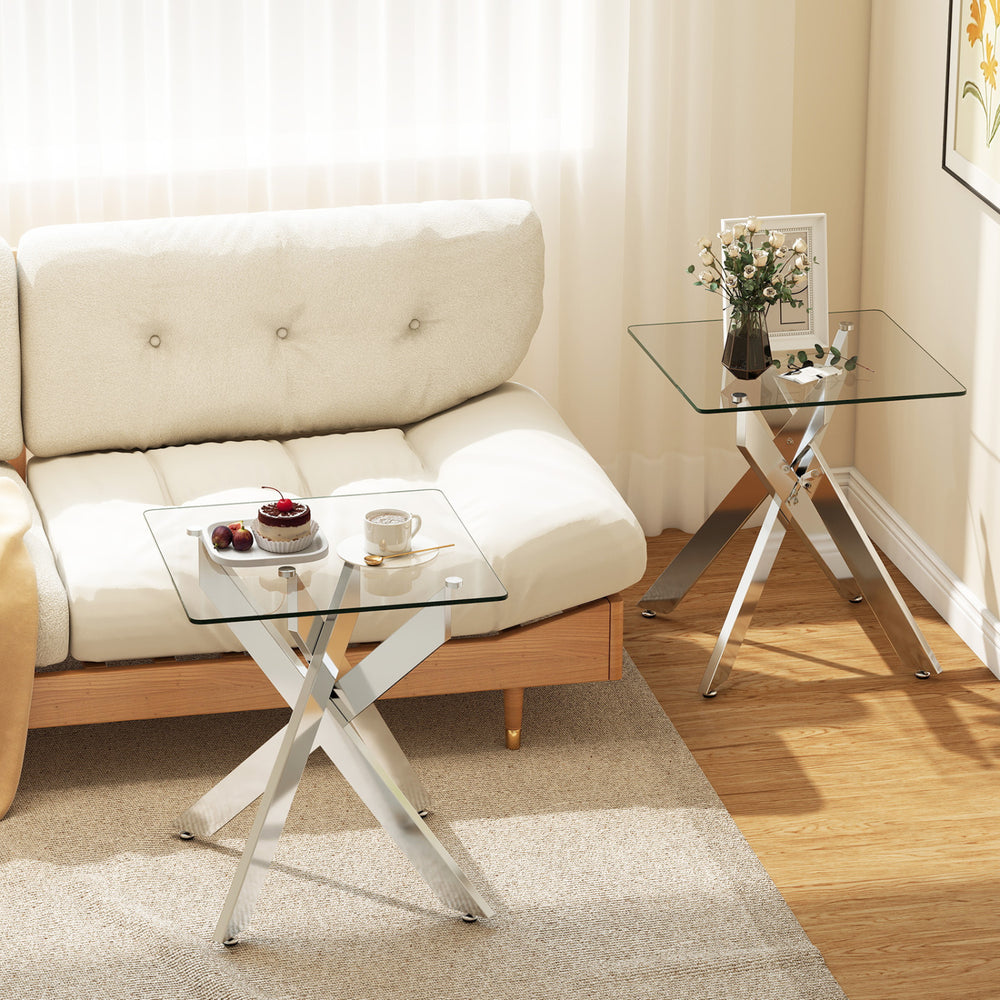 Square glass side table with a sleek tempered glass top and sturdy silver metal X base, ideal for modern living rooms.