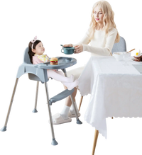 Convertible gray baby high chair with removable double tray, featuring a safety harness and smooth, easy-to-clean seat.
