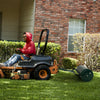 Metal lawn roller with detachable gripping handle, 17-gallon capacity, used for flattening lawns in a yard.