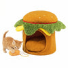 Hamburger-shaped cat nest with removable cushion and plush chicken drumstick toy for indoor cats' comfort and play.