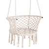 Macrame swing chair in beige with elegant fringe, made of cotton rope for comfortable indoor or outdoor relaxation.