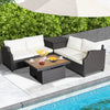 Hand-woven wicker outdoor furniture set with white cushions and acacia wood coffee table, perfect for poolside.