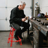 Heavy-duty aluminum garage bar chair in red with 360° swiveling seat, ideal for workshop use and stability.