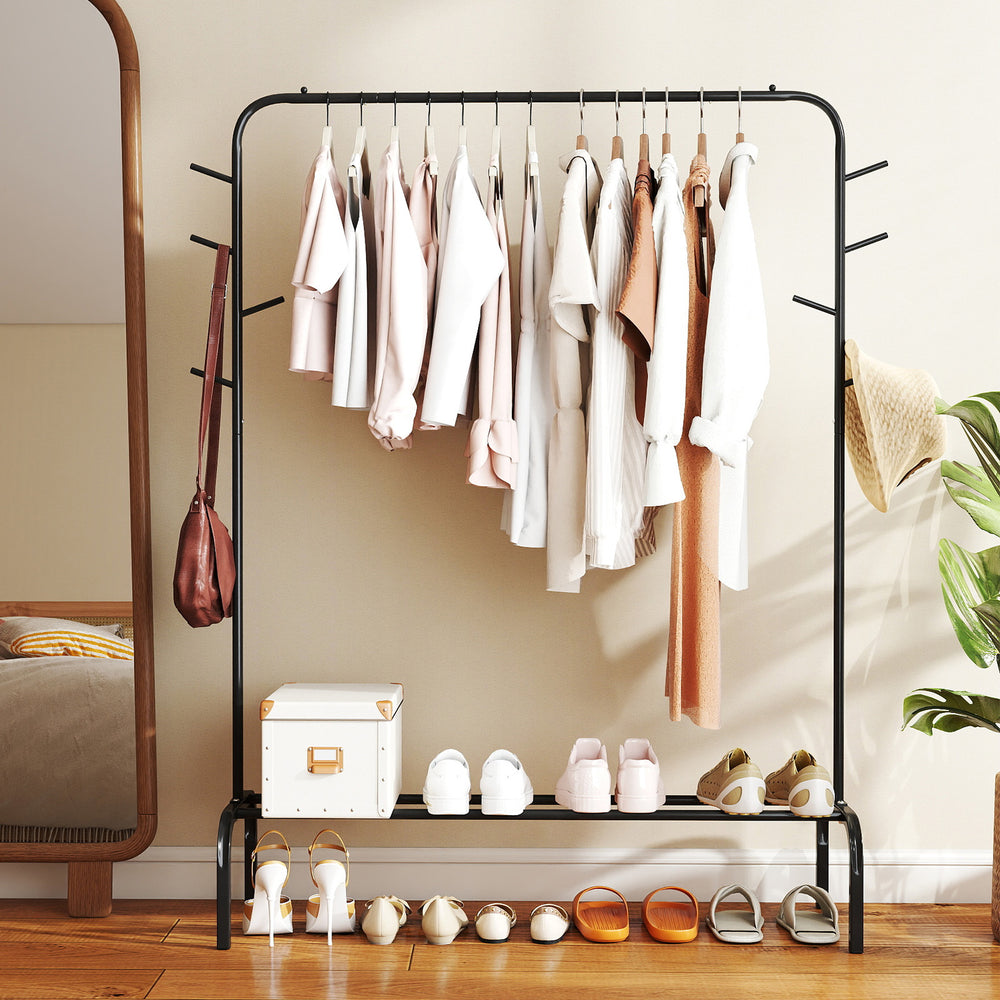 Heavy duty black metal garment rack with hanging clothes, side hooks, and bottom shelf for versatile storage solutions.