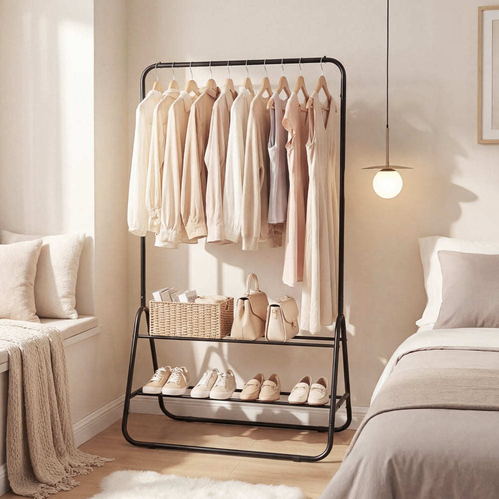 Heavy duty black clothes rack with hanging rod and two storage shelves, ideal for bedroom or laundry room organization.