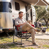 Heavy-duty outdoor camping chair in red with cup holder and side pocket, perfect for relaxation at the campsite.