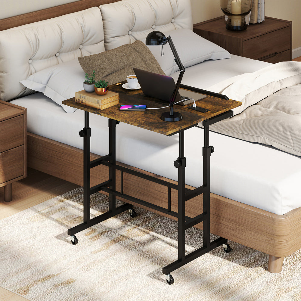 Height adjustable mobile standing desk in rustic brown with wheels, power outlets, and ergonomic tilting tabletop for versatile use.
