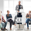 Height adjustable mobile computer stand-up desk in white, perfect for presentations, with storage shelf and wheels for.