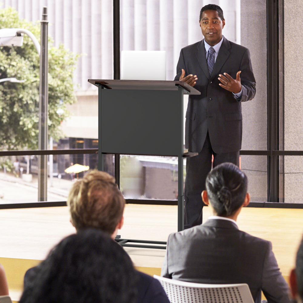 Height adjustable black podium stand with tilted tabletop, stable base, and storage shelf for presentations.