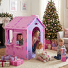 Indoor cottage playset in pink and purple with chimney, featuring kids playing and surrounded by gifts for creative fun.
