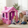 Indoor cottage playset in pink and purple with chimney, featuring two shelves for toys, perfect for creative play.