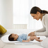 Infant scale with detachable tray, measuring weight and height, shown in use with a baby for growth tracking.
