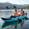 Two people paddling the blue inflatable tandem kayak on a calm lake, featuring heavy-duty design and aluminum paddles.