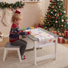Child using the Kids Art Table and Stool Set with paper roll and paint cups for creative drawing in a festive setting.