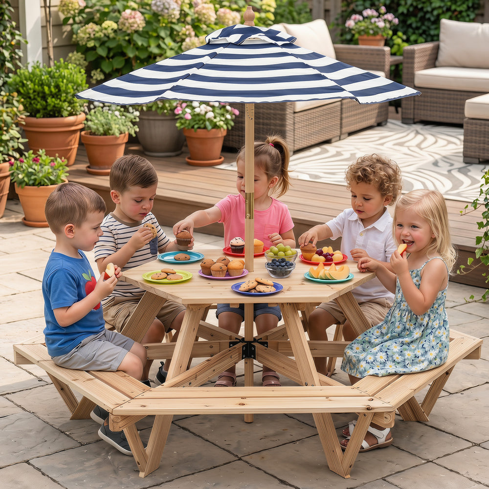 Kids enjoying snacks at a natural wood hexagonal picnic table with an adjustable striped umbrella in a garden setting.