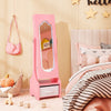 Pink kids jewelry armoire with full-length mirror and LED light stands beside a bed in a decorated child’s bedroom.