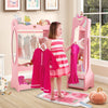 Girl holding dresses in front of a pink kids jewelry armoire cabinet with full-length mirror and ample storage.