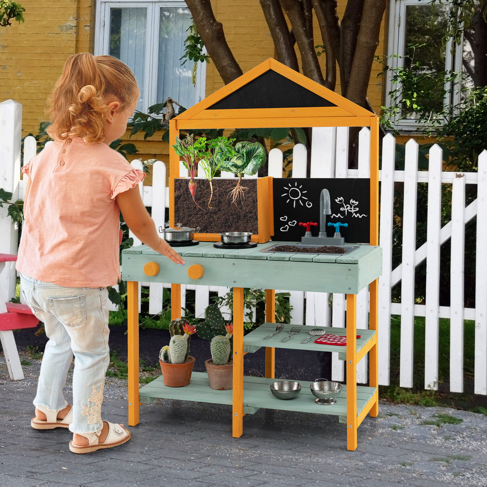 Kids kitchen playset featuring a root viewer planter, rotatable faucet, and chalkboards for creative play in a backyard.