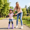 Toddler wearing purple adjustable roller skates with light-up wheels, assisted by an adult in a park setting.