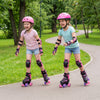 Two girls roller skating in a park wearing adjustable pink roller skates with light-up wheels for outdoor fun.