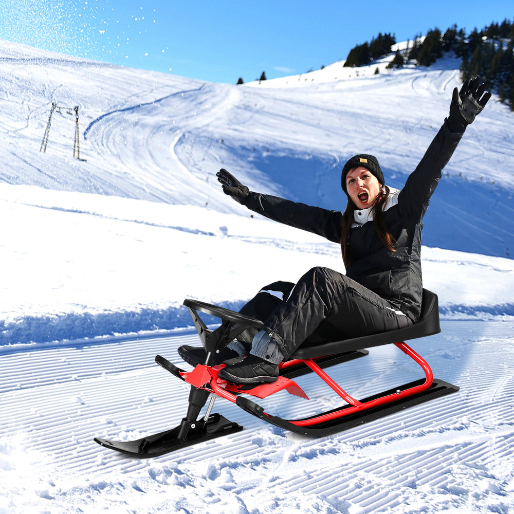 Kids snow sled in red with steering wheel and double brakes, designed for stability and fun in snowy outdoor adventures.