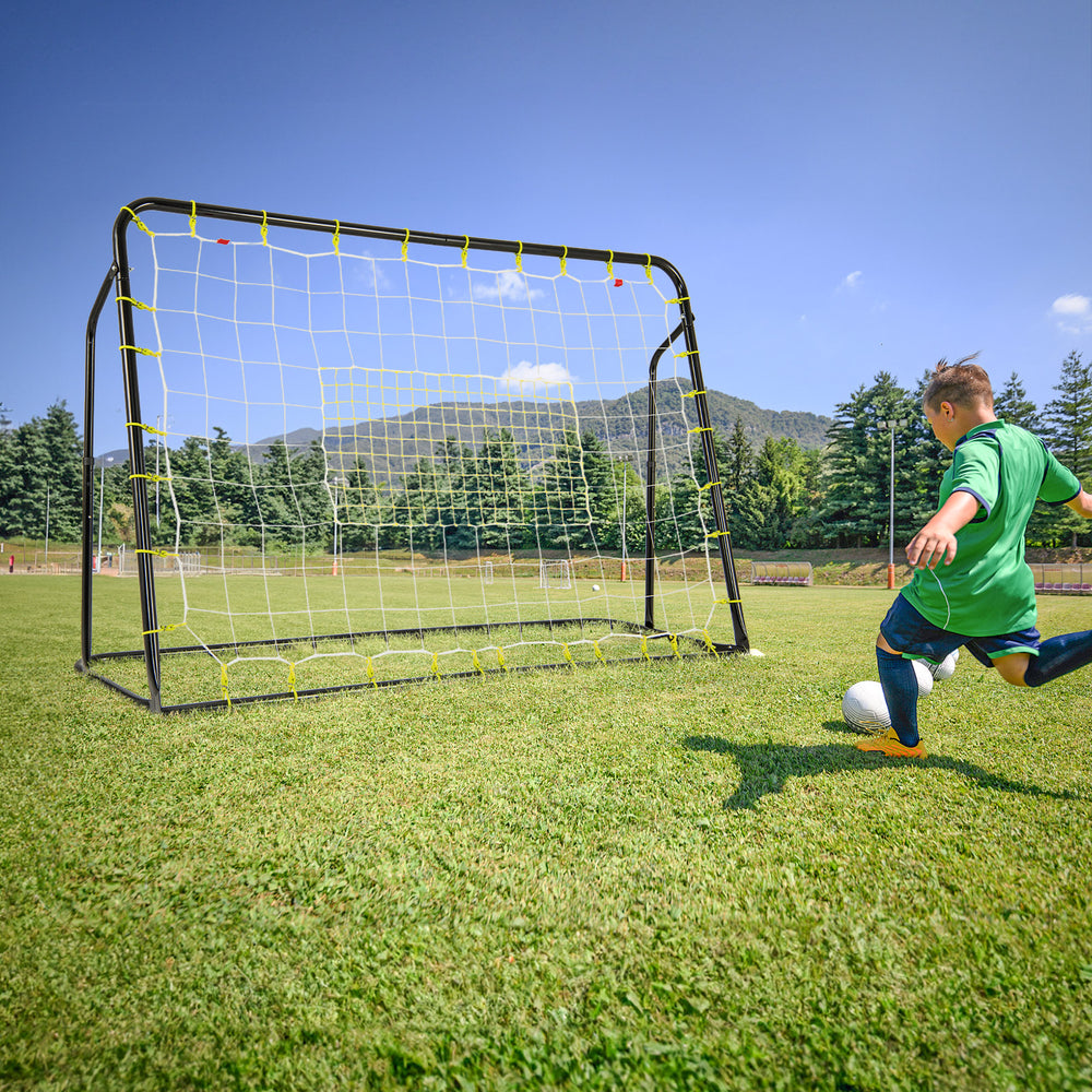 Kids soccer player kicking a ball towards the adjustable 2-in-1 soccer goal and rebounder for outdoor play.