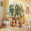 Tree-shaped kids bookshelf in green with open shelves for books and toys, featuring apple cutouts and a stable base.